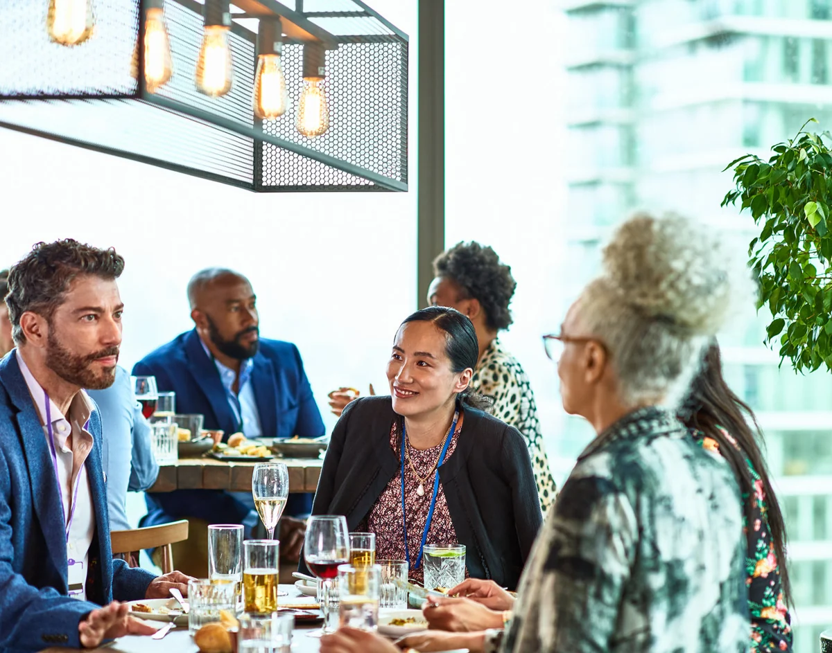 Professionals sharing perspectives around a table at a leadership gathering